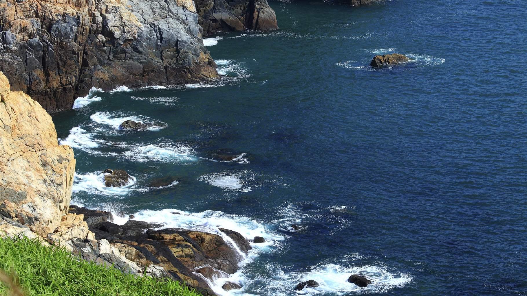 A landscape of rocky mountains on a sea shore